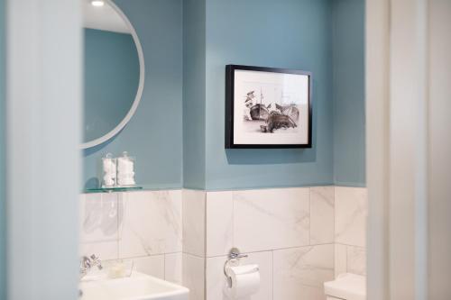 海斯廷斯Moore House的浴室拥有蓝色的墙壁,墙上挂着一幅画