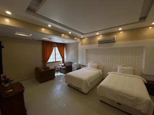 Ḩilf达纳阿尔卡勒酒店的酒店客房带两张床和一个客厅