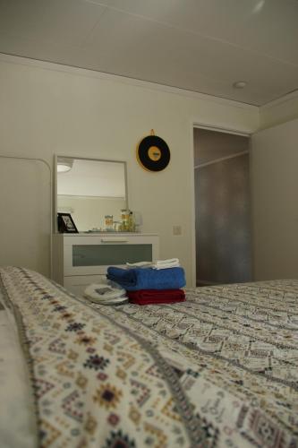 艾尔姆胡尔特Private room for rent in a villa with garden view的卧室配有一张挂在墙上的带时钟的床