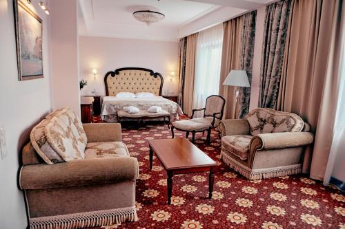 雅罗斯拉夫尔环形高级酒店的客厅配有床、椅子和桌子