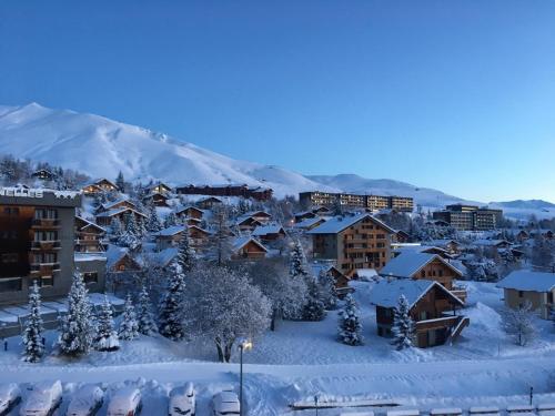 土绪尔Appartement traversant résidence chaput 2 - 2 pièces - 6 personnes - vue sur front de neige的一座被雪覆盖的小镇,背景是一座山