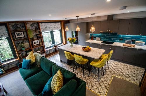 塞德伯Wuthering Heights的厨房配有绿色沙发和带黄色椅子的桌子