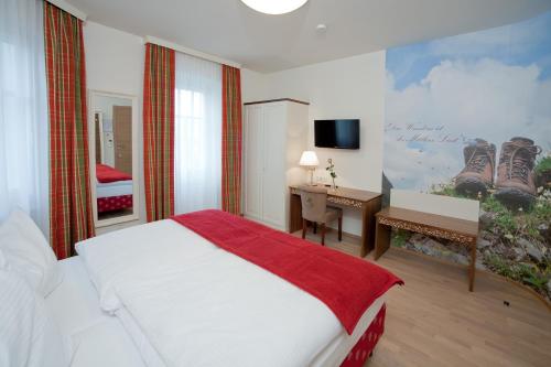 哈特贝格泽姆布劳豪斯餐厅旅馆的一间卧室配有一张床、一张书桌和一台电视