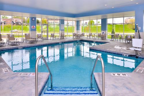 麦迪逊麦迪逊智选假日套房酒店的酒店的大型游泳池配有桌椅