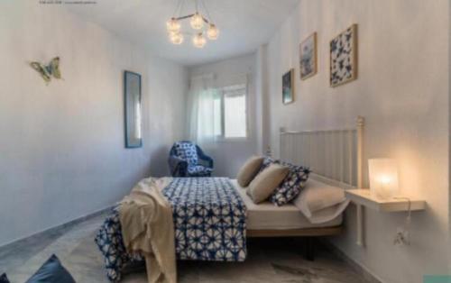 阿尔姆尼卡Villa gaviota的一间卧室配有一张带蓝色毯子的床和窗户。