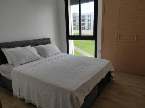 塞拉Bel appartement à plage des Nation的一间卧室设有一张大床和窗户