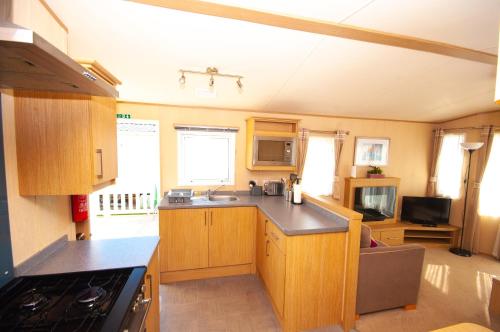 坎伯利Caravan by Camber Sands 2的厨房配有木制橱柜和台面