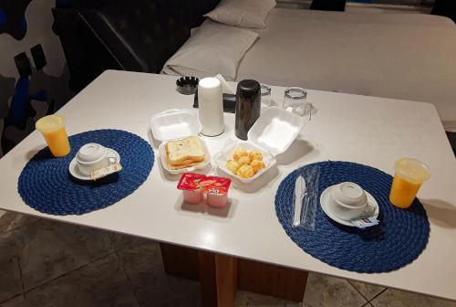 圣贝尔纳多-杜坎普Motel Ilha de Capri的一张桌子上放着两个蓝色的食物盘