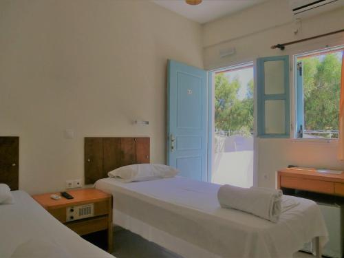 费拉圣托里尼岛露营/客房酒店的配有窗户和床罩的宿舍间内的两张床
