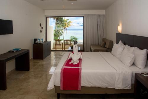 艾库玛尔Akumal Bay Beach & Wellness Resort的酒店客房,配有一张带盒子的床