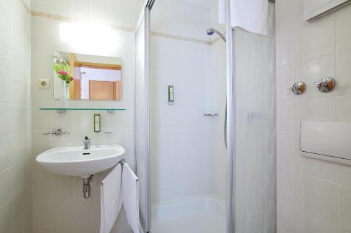 CallenbergTannmühle Hotel und Restaurant GmbH的白色的浴室设有水槽和淋浴。