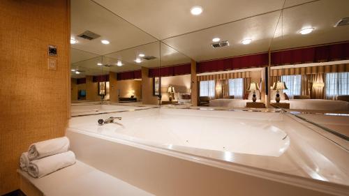 棕榈泉贝斯特韦斯特拉斯布来萨酒店的设有带大镜子的浴室的大浴缸