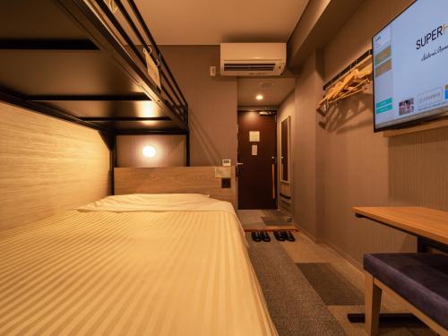 名取市Super Hotel Sendai Airport Inter的一间酒店客房,配有一张床和一台电视
