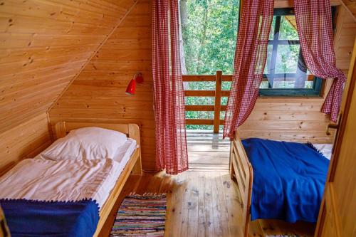 波别罗沃松木山林小屋的小木屋内一间卧室,配有两张床