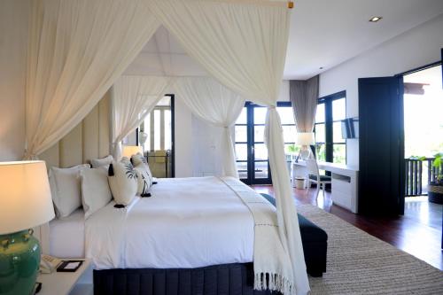 塞米亚克阿卡拉别墅酒店的卧室配有带窗帘的大型白色床