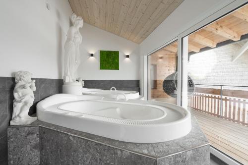 巴尔德赫旺Kienle - das Kräuterhotel的浴室设有大浴缸和雕像