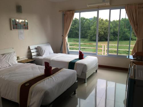 卡农西里布里度假酒店的一间卧室设有两张床和大窗户