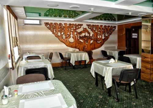 尼古拉耶夫Green City Hotel的一间带2张桌子和吊灯的用餐室
