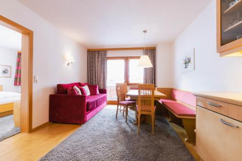 莱赫阿尔贝格布劳纳尔公寓的客厅配有红色的沙发和桌子