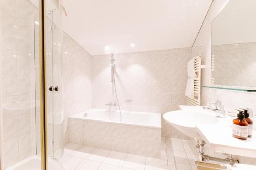 莱赫阿尔贝格布劳纳尔公寓的白色的浴室设有浴缸和水槽。