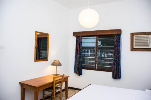 达累斯萨拉姆Baobab Village One Bedroom apartment - Type I的客房设有书桌、窗户和桌子。