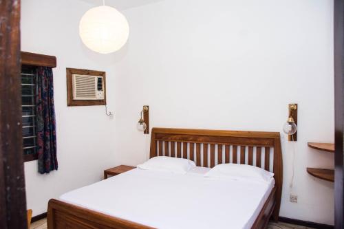 达累斯萨拉姆Baobab Village One Bedroom apartment - Type I的一间卧室配有白色床单