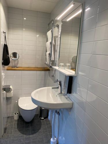锡格蒂纳锡格蒂纳斯蒂弗特尔森酒店与会议中心的一间带水槽、卫生间和镜子的浴室