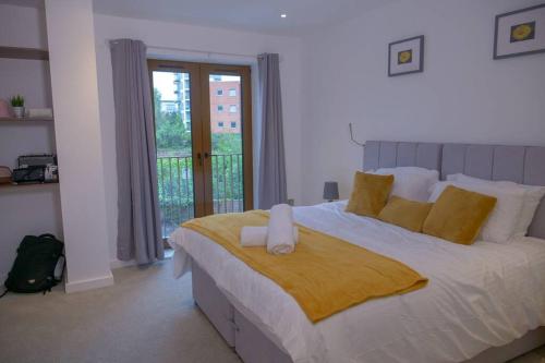 圣奥尔本斯Maplewood properties - St Albans one bedroom luxurious flat的卧室配有一张带黄色枕头的大型白色床。