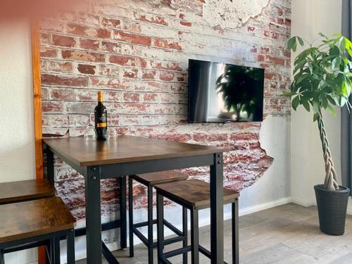 科特布斯Industry - Appartement mit Balkon的砖墙,带桌子和一瓶葡萄酒