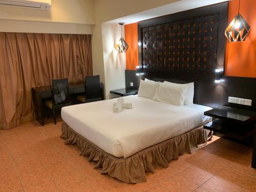 Kampong PenagaResort Suites by Landmark at Bandar Sunway Sunway Lagoon的一间卧室配有一张白色大床和黑色床头板