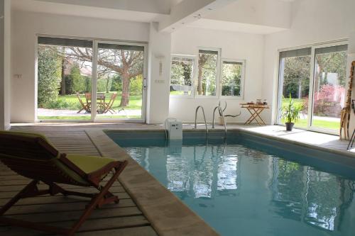 Petit-Réderching玛丽亚别墅酒店的房屋设有游泳池、椅子和窗户