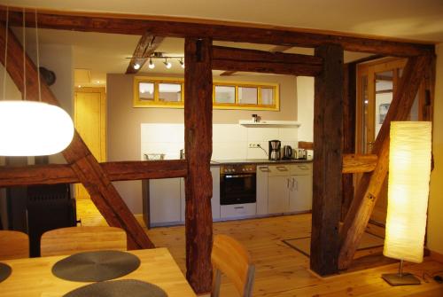 艾恩贝克Gästehaus in Sülbeck的一间带木梁和桌子的厨房(位于客房内)
