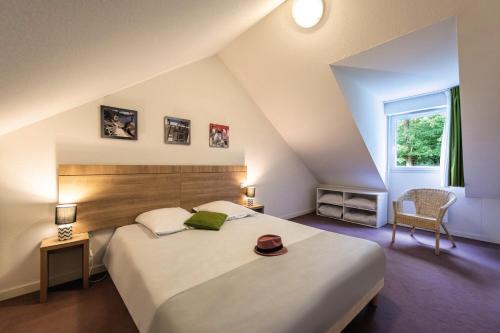 索米尔Terres de France - Le Domaine Du Golf的一间卧室配有一张大床,上面有帽子