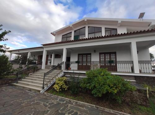 Vale de PorcoVivenda das Eiras的白色的房子,前面有楼梯