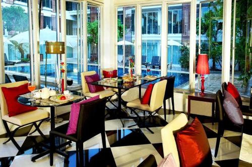 乌隆他尼乌隆府天堂酒店的用餐室设有桌椅和窗户。