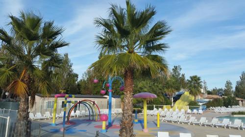 维亚斯Mobil home La Mer的游泳池内种有棕榈树的游乐场