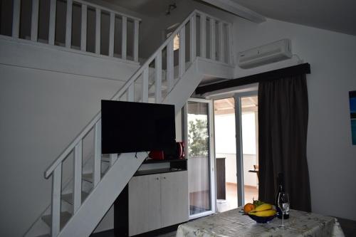 格雷巴蒂卡VILLA LAURA的客厅设有楼梯和平面电视