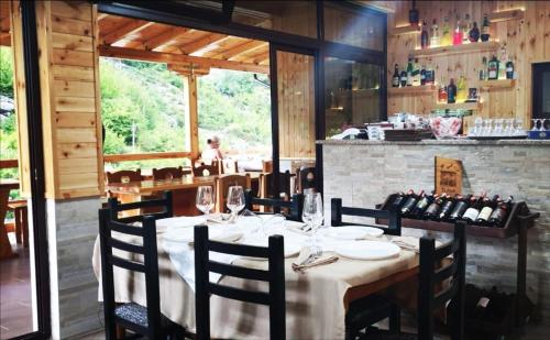 TamarëBar Restaurant Hotel ''Te Gusti''的用餐室配有桌椅和葡萄酒瓶