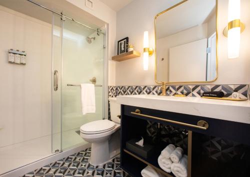 格林斯伯勒Hotel Denim的一间带卫生间和玻璃淋浴间的浴室