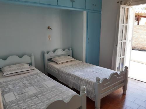 卡塔科隆Villa Evdokia的卧室设有两张床,拥有蓝色的墙壁和窗户。