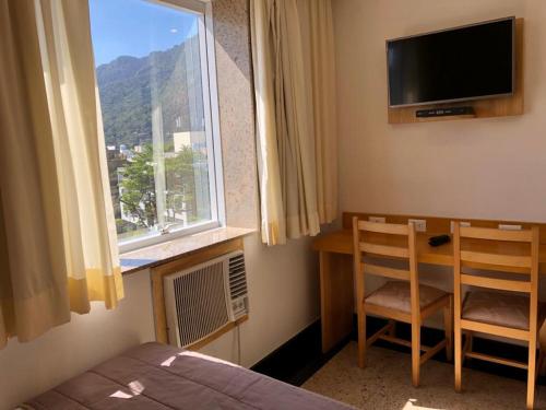 里约热内卢热带巴拉酒店的一间卧室配有一张床、一个窗口和一张书桌