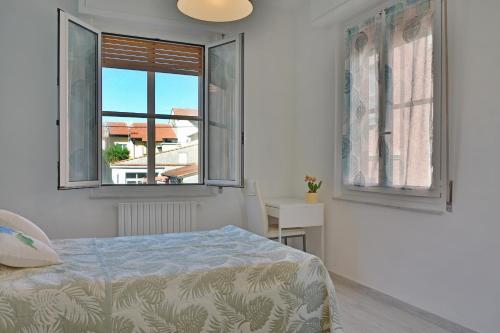 阿尔本加Agriturismo La Casa degli Zii的一间卧室设有一张床和两个窗户。