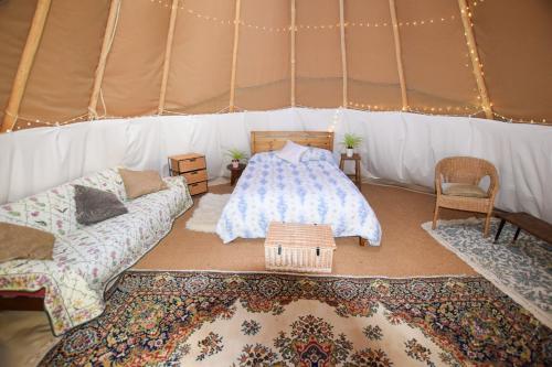 比灵斯赫斯特Dragonfly Lodge Ifold & Alpaca My Tipi Glamping的带帐篷的房间,配有一张床和地毯