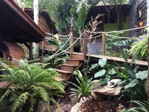 瓜尔达恩巴Pousada Piratas do Embaú的一座拥有木楼梯和植物的花园