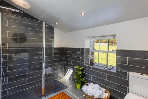 SilecroftWhicham Hall的浴室设有黑色瓷砖淋浴。