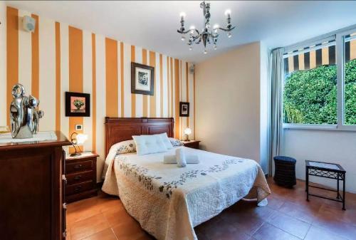 阿洛拉Ático Guadalhorce - Mirador privado con barbacoa y solárium的一间卧室配有一张床、一个梳妆台和一扇窗户。