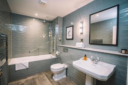格拉斯米尔Bridge House Hotel & Silver Howe View Cottage的浴室配有盥洗盆、卫生间和浴缸。