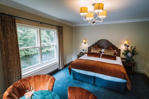 格拉斯米尔Bridge House Hotel & Silver Howe View Cottage的一间卧室配有一张床和两把椅子
