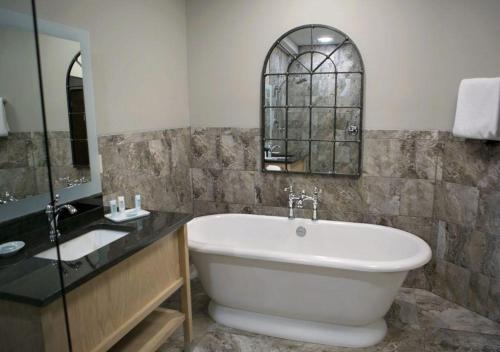 StaplesTimberlake Hotel的带浴缸、水槽和镜子的浴室