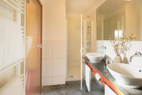 豪恩斯泰因Waldhotel Felsentor的一间带两个盥洗盆和淋浴的浴室